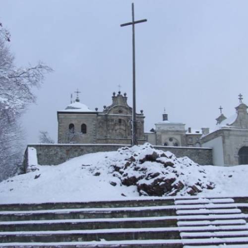 Klasztor od strony wschodniej oraz Krzyż misyjny postawiony na pamiątkę przybycia Ojców Oblatów